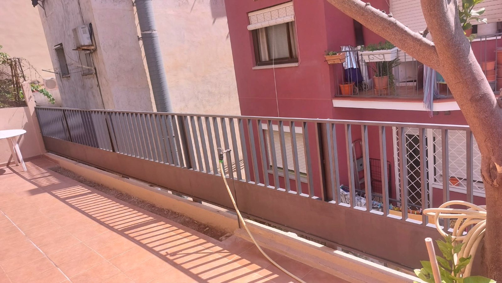 Barandilla metálica gris a lo largo de una terraza