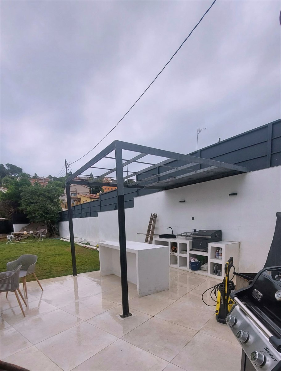 Estructura de pérgola metálica negra en una terraza