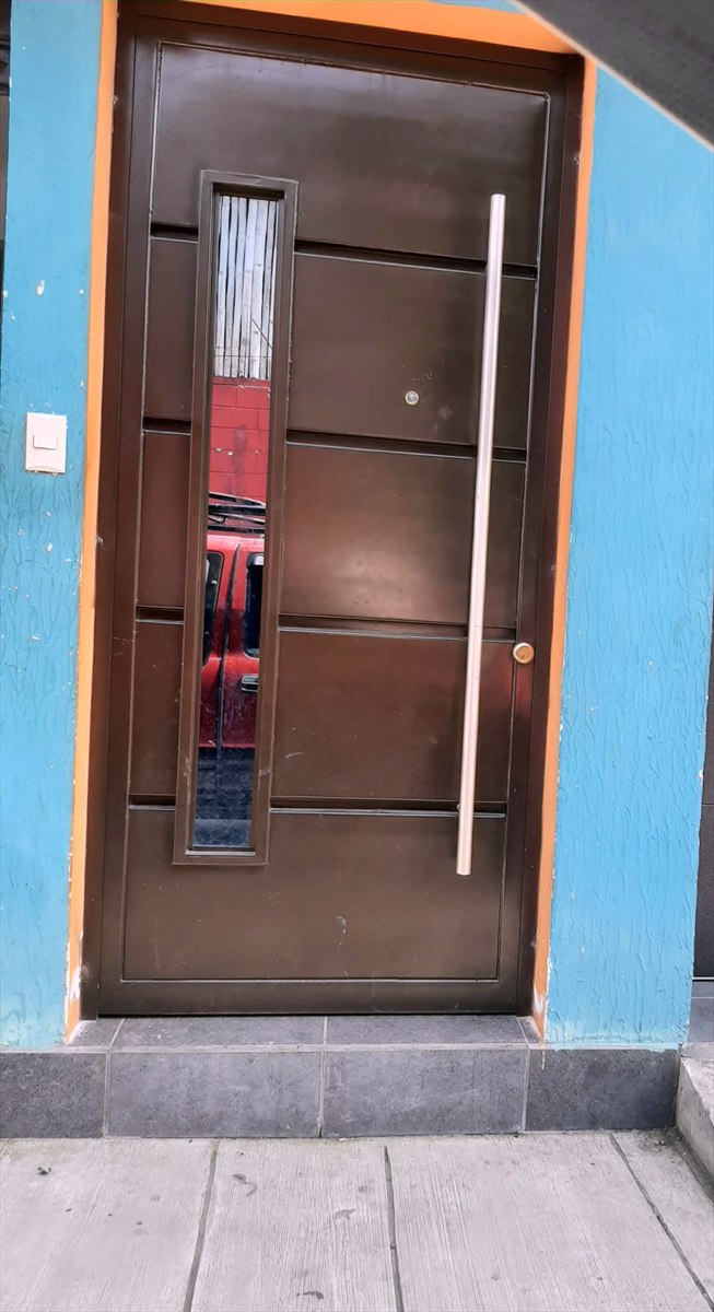 Puerta de entrada metálica con mirilla vertical y tirador largo